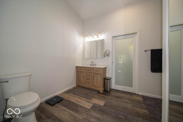 11815 E Pocahontas Dr, Greencastle, IN 46135 - bathroom with wood finished floors, vanity, toilet, vaulted ceiling, and baseboards