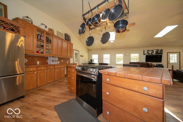 11815 E Pocahontas Dr, Greencastle, IN 46135 - kitchen with stainless steel appliances, lofted ceiling, brown cabinets, tile countertops, and light wood-type flooring