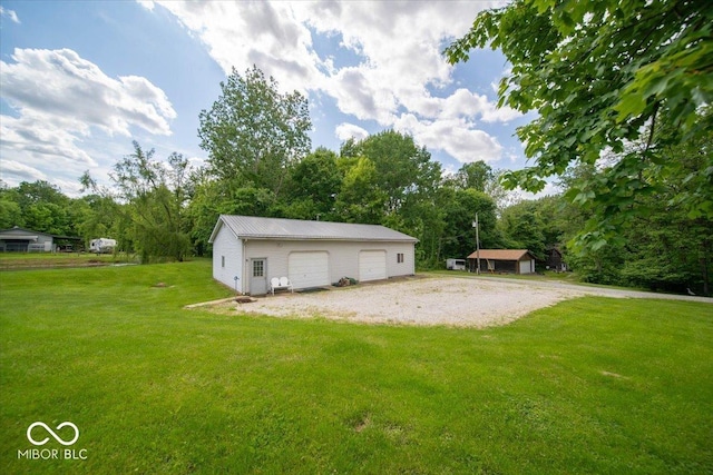 11815 E Pocahontas Dr, Greencastle, IN 46135 - view of green lawn featuring a garage, an outdoor structure, and view of wooded area