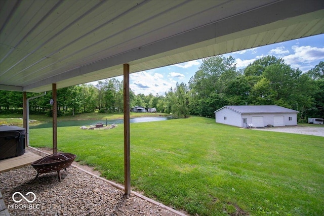 11815 E Pocahontas Dr, Greencastle, IN 46135 - view of green lawn with a fire pit, a detached garage, a water view, and view of scattered trees