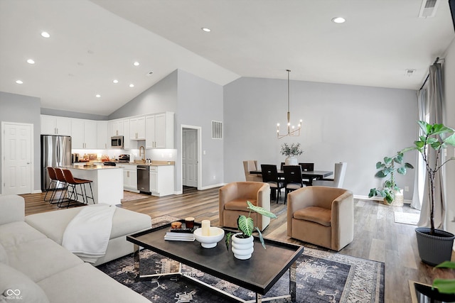 5580 Pintail Ln, Greenwood, IN 46143 - living area featuring light wood-style flooring, a chandelier, baseboards, recessed lighting, and high vaulted ceiling