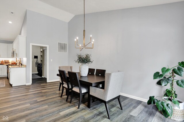 5580 Pintail Ln, Greenwood, IN 46143 - dining space featuring a chandelier, dark wood finished floors, baseboards, and high vaulted ceiling