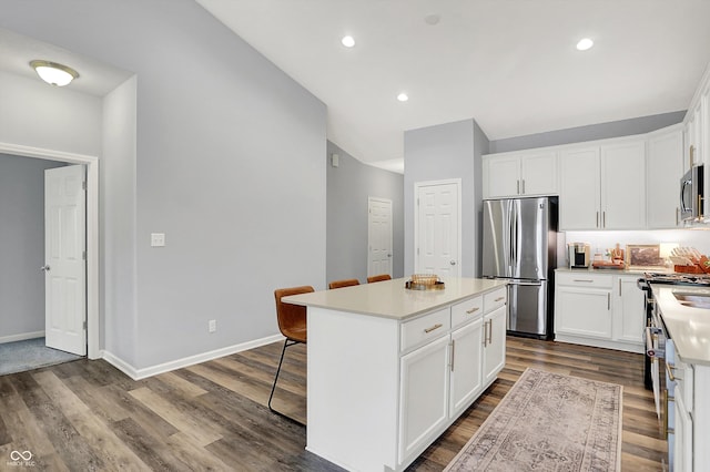 5580 Pintail Ln, Greenwood, IN 46143 - kitchen featuring stainless steel appliances, dark wood-type flooring, a kitchen island, a kitchen breakfast bar, and white cabinets