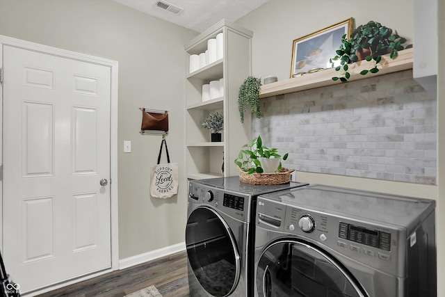 5580 Pintail Ln, Greenwood, IN 46143 - clothes washing area featuring washing machine and dryer, dark wood-type flooring, baseboards, and cabinet space