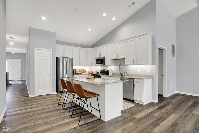 5580 Pintail Ln, Greenwood, IN 46143 - kitchen with stainless steel appliances, high vaulted ceiling, a sink, a kitchen bar, and a kitchen island