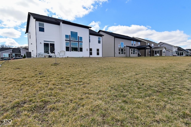 back of property with a yard and a residential view