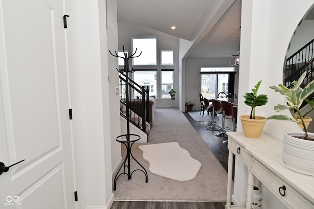 foyer entrance featuring dark wood finished floors, baseboards, vaulted ceiling, and stairs