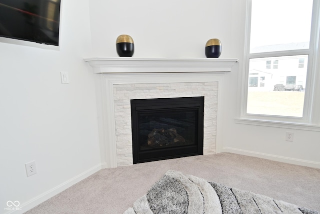 room details featuring carpet floors, baseboards, and a glass covered fireplace
