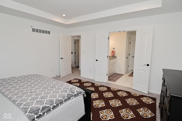 bedroom featuring light colored carpet, a tray ceiling, visible vents, and recessed lighting