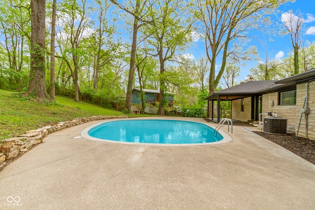 view of pool with a fenced in pool, fence, a patio area, and central AC