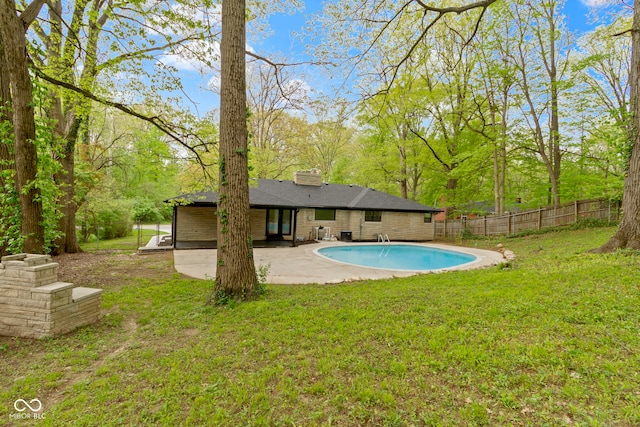 view of swimming pool featuring fence, a fenced in pool, a lawn, and a patio area