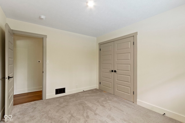 carpeted spare room with baseboards and visible vents