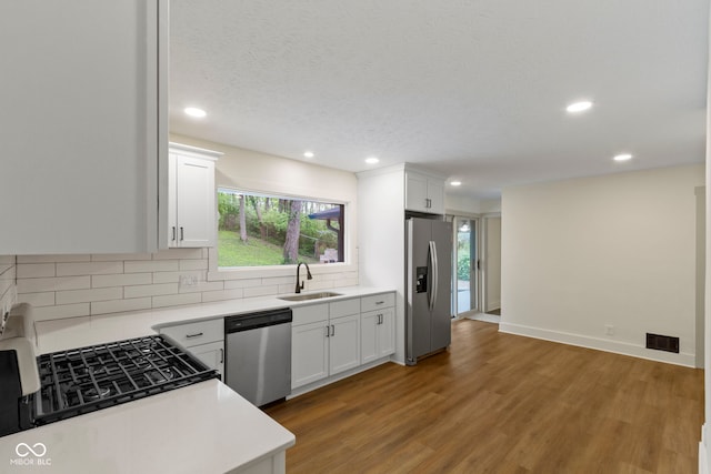 kitchen with backsplash, visible vents, a sink, stainless steel appliances, and recessed lighting