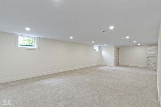 below grade area featuring recessed lighting, baseboards, light carpet, and a wealth of natural light