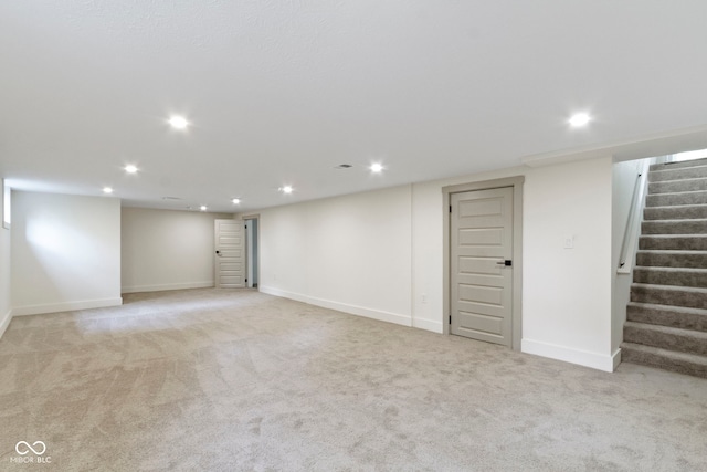 finished basement with stairs, recessed lighting, baseboards, and light colored carpet