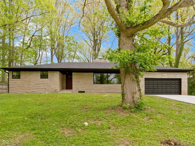 view of front facade featuring driveway, a chimney, a front yard, an attached garage, and stone siding