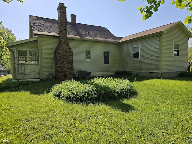 view of home's exterior featuring crawl space, cooling unit, a yard, and a chimney