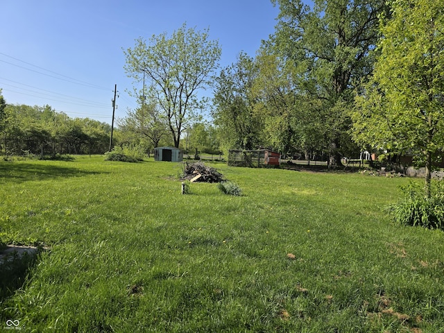 view of green lawn with a shed and an outdoor structure