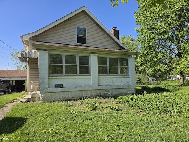 view of side of property with brick siding and a chimney