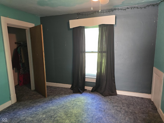 unfurnished bedroom featuring multiple windows, carpet, and baseboards