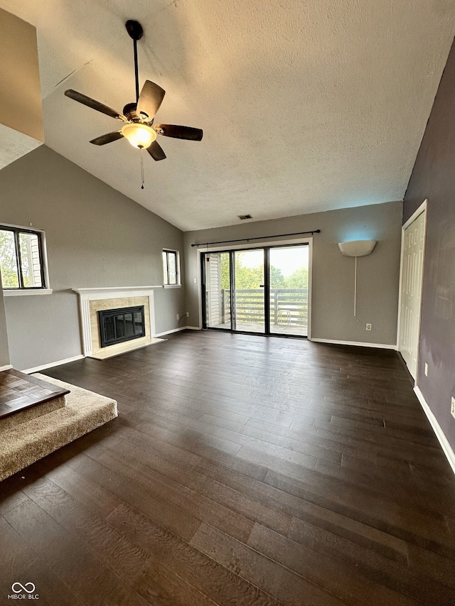 unfurnished living room featuring ceiling fan, a textured ceiling, dark wood finished floors, baseboards, and lofted ceiling