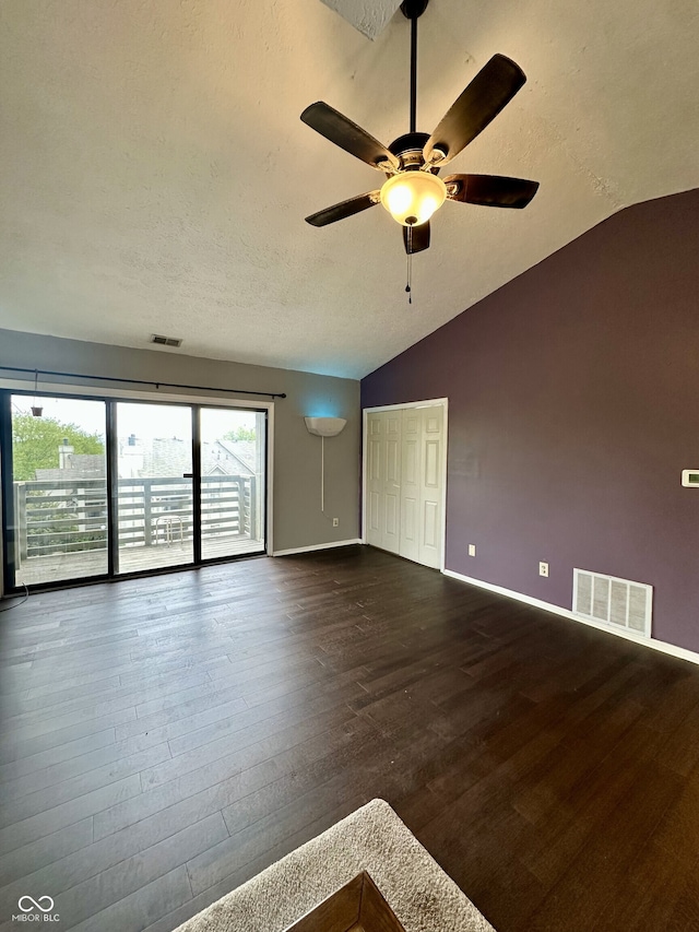 unfurnished room with ceiling fan, lofted ceiling, dark wood-style flooring, and visible vents
