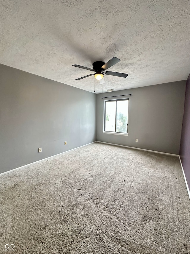 unfurnished room featuring carpet flooring, a ceiling fan, and a textured ceiling