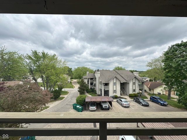 exterior space with a residential view, uncovered parking, and a balcony