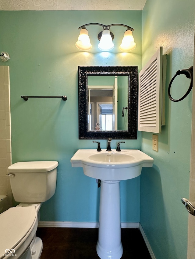 bathroom featuring toilet and baseboards