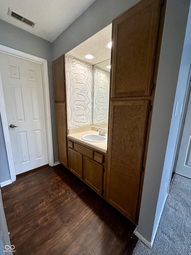 bathroom with visible vents, wood finished floors, vanity, baseboards, and recessed lighting