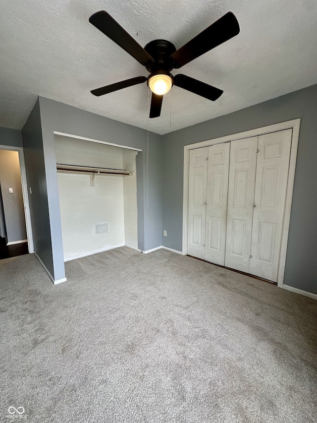 unfurnished bedroom featuring baseboards, a textured ceiling, carpet, and ceiling fan