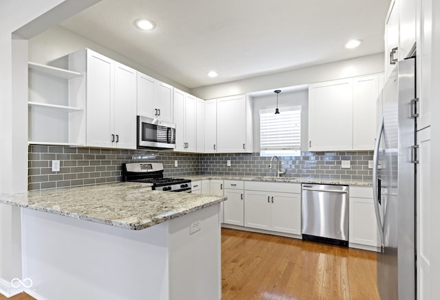 2940 N Park Ave, Indianapolis, IN 46205 - kitchen featuring appliances with stainless steel finishes, open shelves, a sink, a peninsula, and white cabinets