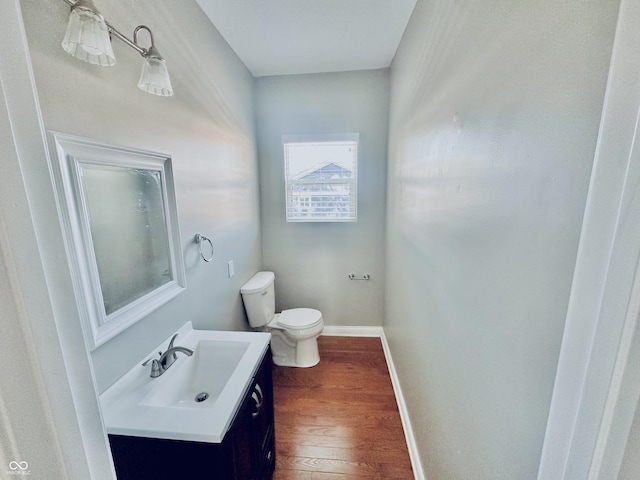 2940 N Park Ave, Indianapolis, IN 46205 - half bathroom with wood finished floors, toilet, vanity, and baseboards