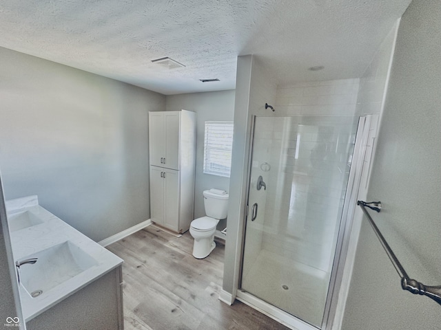 2940 N Park Ave, Indianapolis, IN 46205 - bathroom featuring a stall shower, wood finished floors, toilet, a textured ceiling, and baseboards