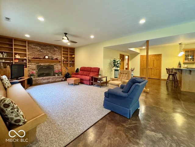living area featuring built in shelves, ceiling fan, recessed lighting, finished concrete flooring, and bar