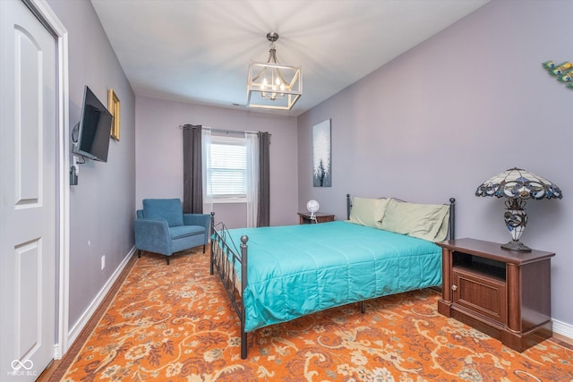 bedroom featuring baseboards and a chandelier