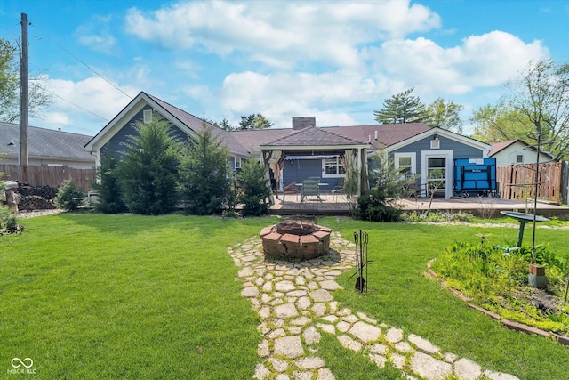 view of front facade featuring a front lawn, a fire pit, fence, and a deck