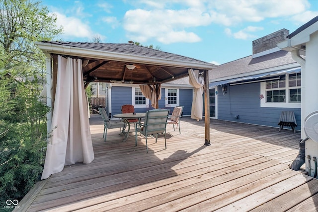 wooden terrace with a gazebo and outdoor dining area