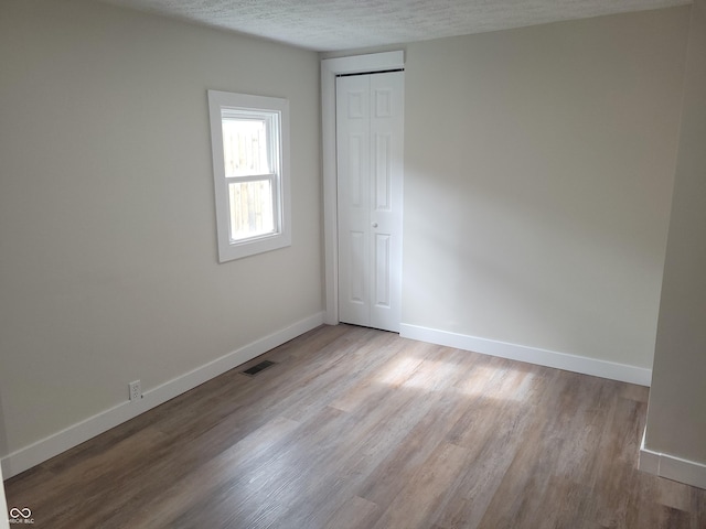 2855 Walker Ave, Indianapolis, IN 46203 - unfurnished room featuring baseboards, a textured ceiling, wood finished floors, and visible vents