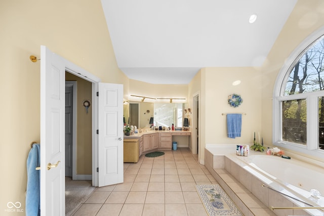 6821 Ripple Creek Dr, Lafayette, IN 47905 - bathroom with tile patterned flooring, vaulted ceiling, a tub with jets, vanity, and baseboards