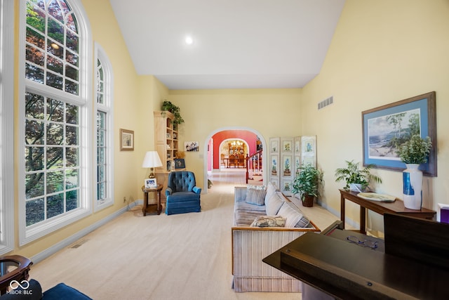 6821 Ripple Creek Dr, Lafayette, IN 47905 - carpeted living room with arched walkways, high vaulted ceiling, visible vents, and a healthy amount of sunlight