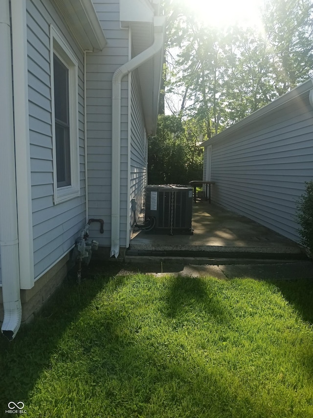 view of home's exterior with central AC unit, a wooden deck, and a lawn