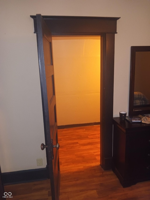 hallway featuring baseboards and wood finished floors
