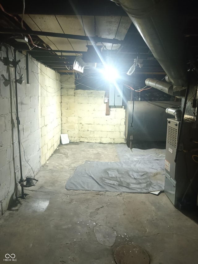 unfinished below grade area featuring electric panel and heating fuel