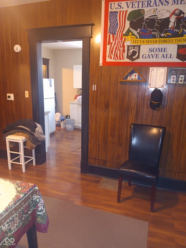 living area with dark wood finished floors and wood walls