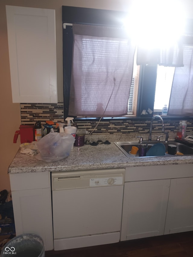kitchen featuring backsplash, white cabinetry, a sink, and dishwasher