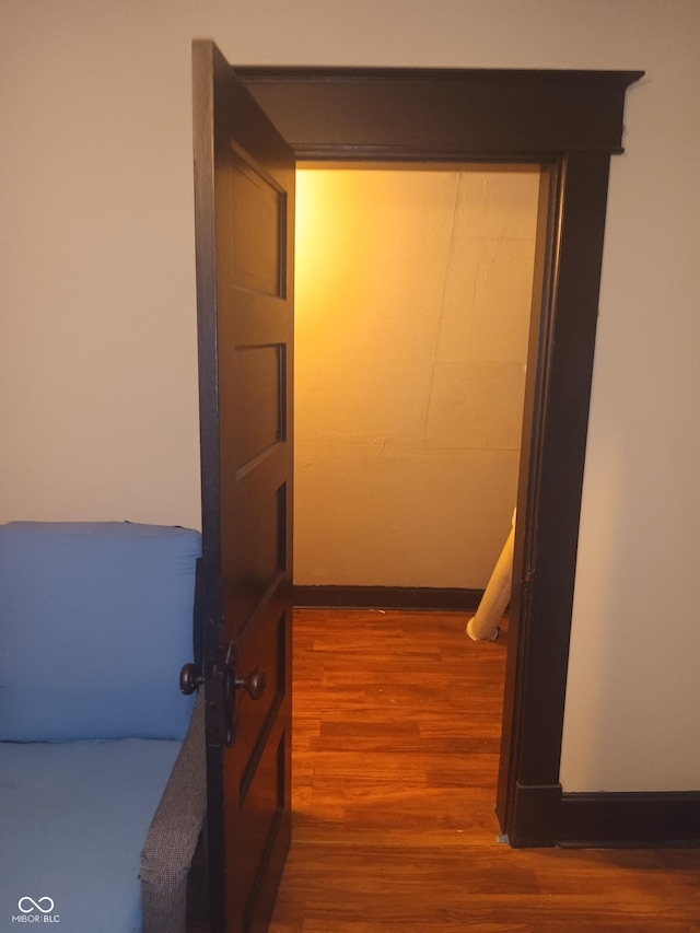 corridor featuring baseboards and wood finished floors