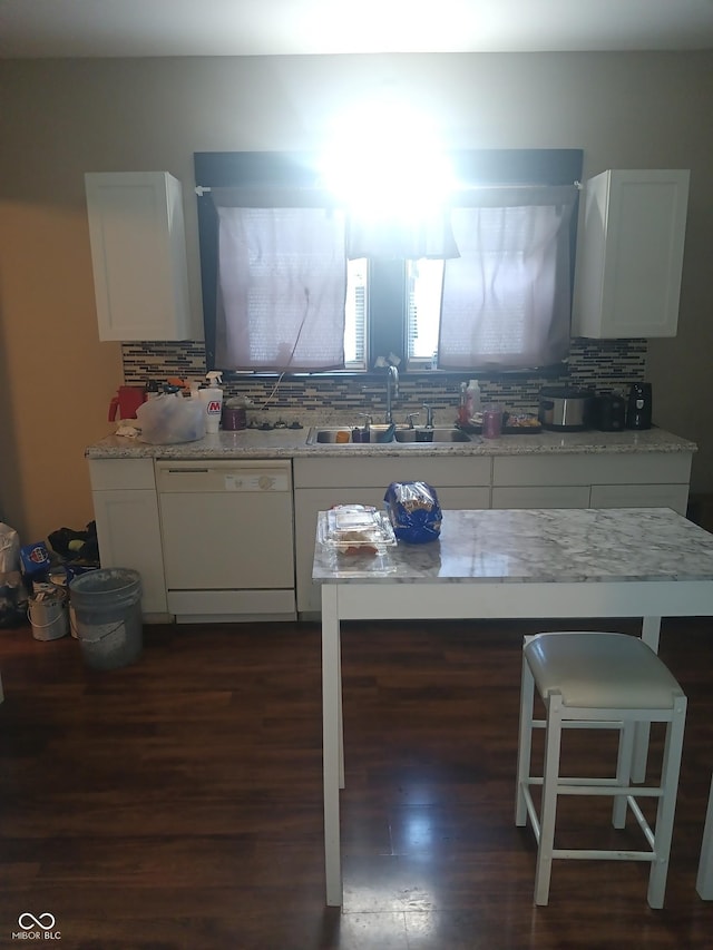 kitchen featuring white cabinetry, backsplash, a sink, and dishwasher