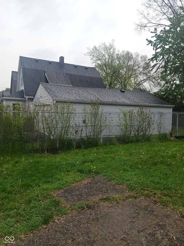 view of home's exterior featuring roof with shingles and fence