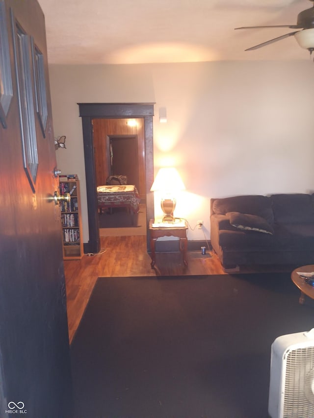 living area with a ceiling fan and wood finished floors